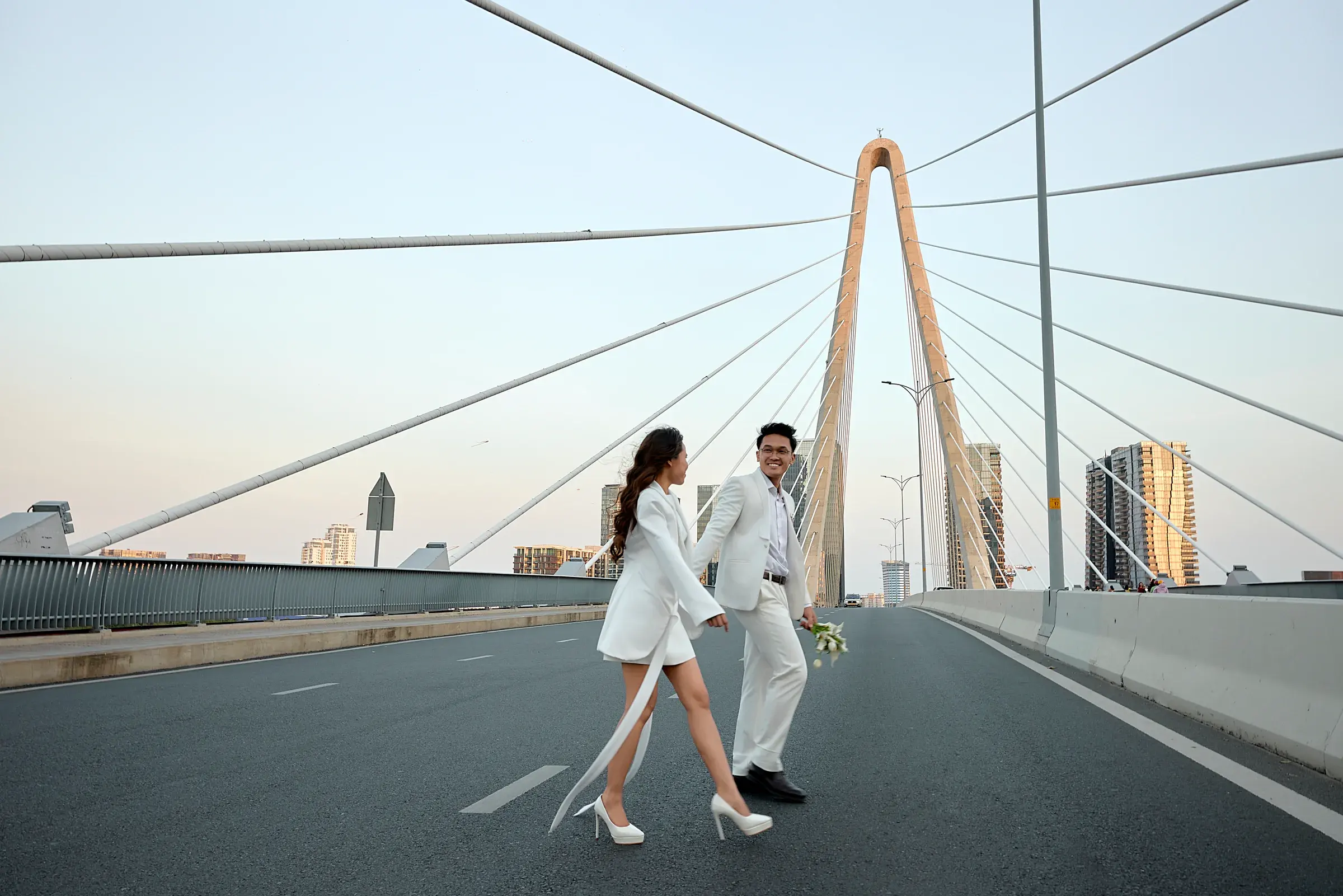 Josh and Analie walking hand in hand on a bridge