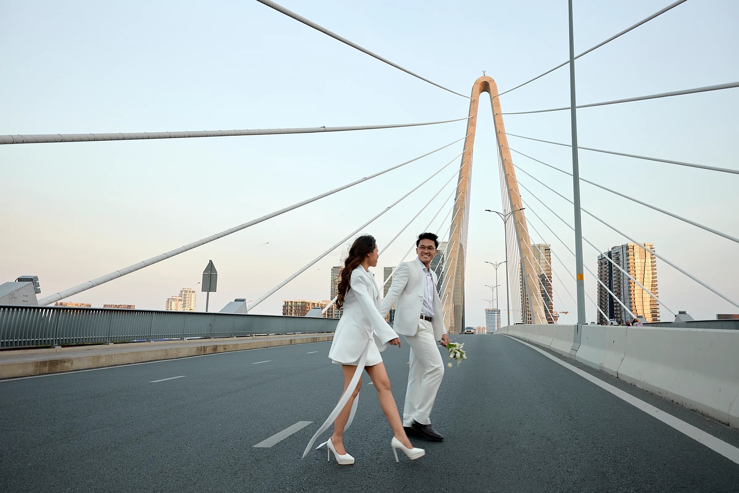 Josh and Analie walking hand in hand on a bridge
